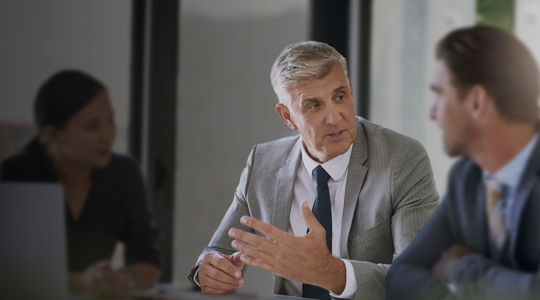 Image shows three people having a business meeting